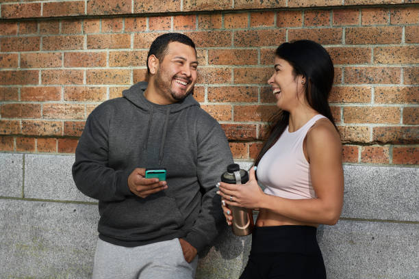 istock sportsman using phone by friend against brick wall 1138343306