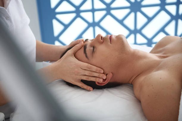 istock Young man enjoying lifting massage of face 1138346021