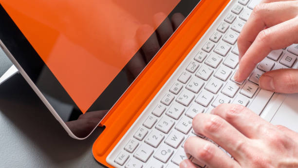Male hands and white orange convertible laptop