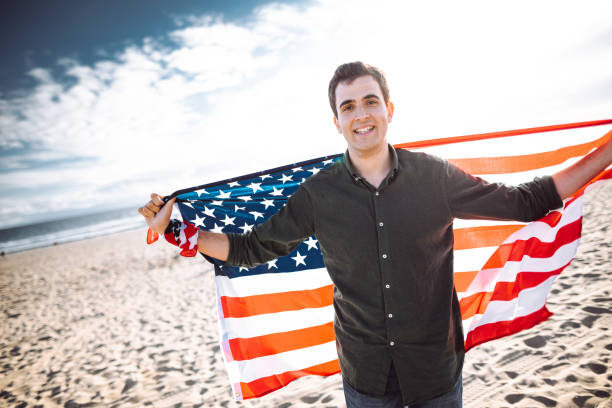 istock man with us national flag on the beach 1138351778