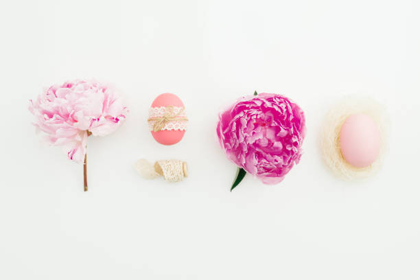istock Ester festive composition with eggs, pink peonies flowers on white background. Flat lay 1138353260