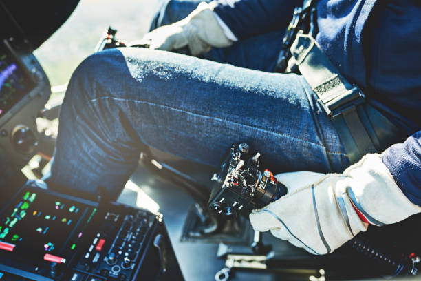 Shot of an unrecognizable  pilot steering an helicopter with a joystick during the day