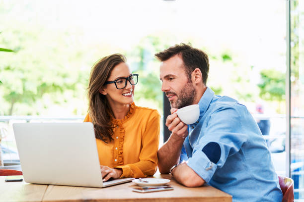 istock Couple talking at cafe using laptop and drinking cofee 1138353573