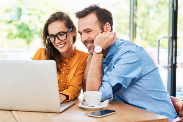 istock Woman and man at cafe using laptop. Couple spending time at cafeteria browsing internet on computer 1138353628