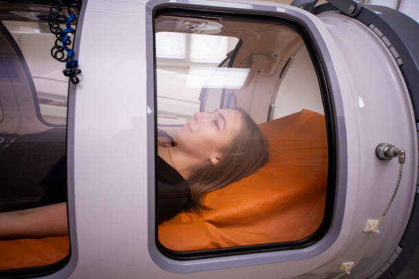 beautiful girl in a hyperbaric chamber, oxygen treatment - compartimento de armazenamento imagens e fotografias de stock