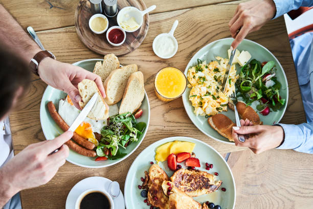 overhead picture of couple eating tasty breakfast at restaurant - french toast breakfast food sweet food imagens e fotografias de stock