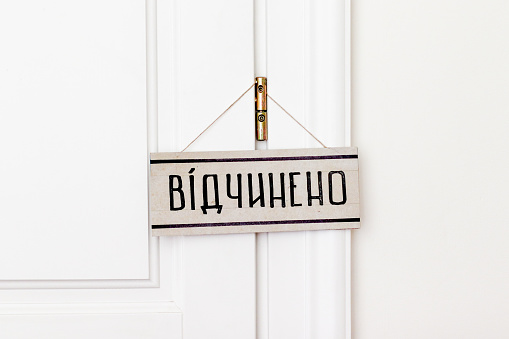 Plate is open on a white wooden door. Text in Ukrainian