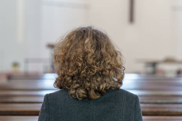 istock Devout religious woman praying in a church 1138355477