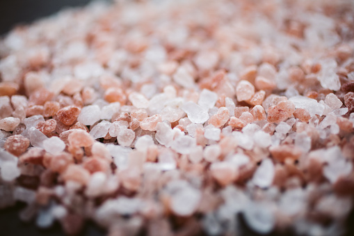 Pink Himalayan salt background with selective focus. Abstract texture and background made of pink Himalayan salt.