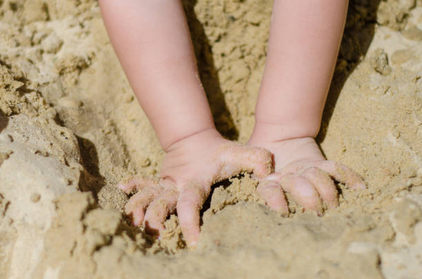 istock hands of a child digging sand 1138357320
