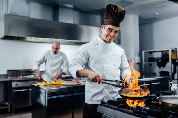 Cropped shot of a young male chef preparing the meal in a professional kitchen