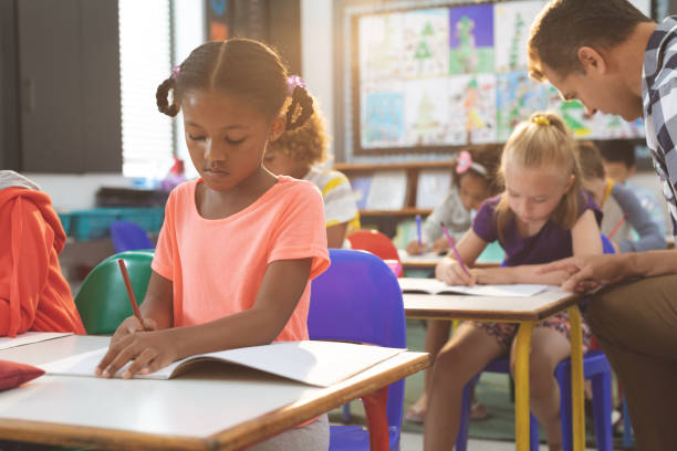 istock Schoolgirl  studying at desk in a classroom at school 1138358662