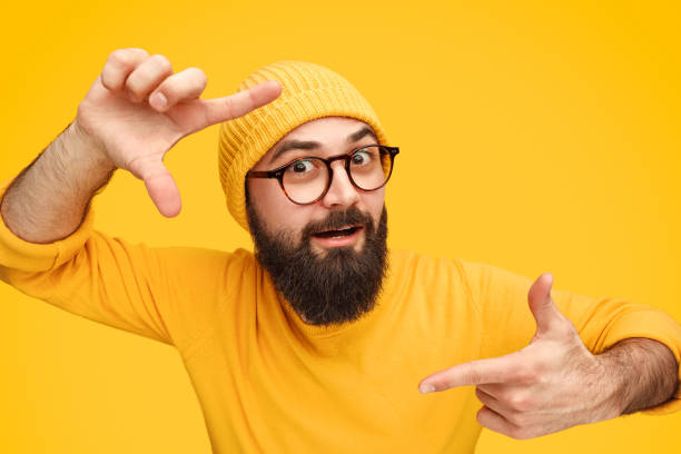 istock Bearded man holding hands in shape of camera focus 1138358760
