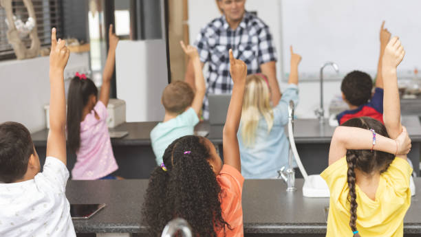 istock School kids raising hand while teacher asking question 1138359389
