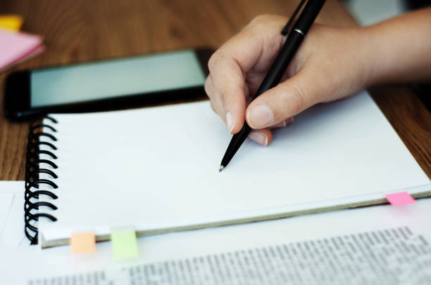 istock hand of young woman drawing on notebook. 1138360273