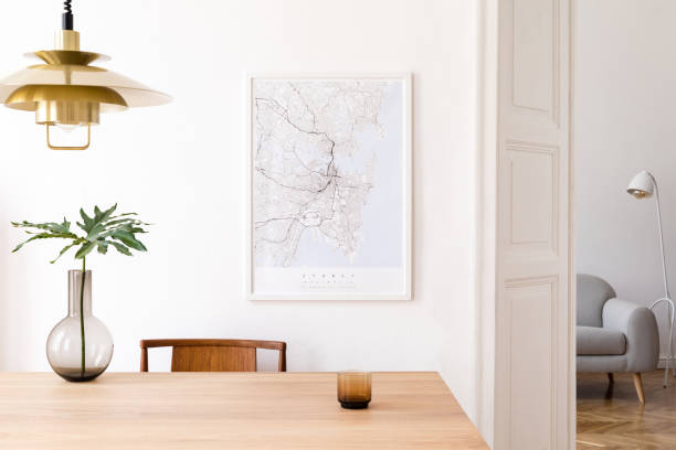 Stylish and eclectic dining room interior with mock up poster map, sharing table design chairs, gold pedant lamp and elegant sofa in second space. White walls, wooden parquet. Tropical leafs in vase. Stylish and modern dining room interior with mock up poster. Eclectic decor. wooden bleachers stock pictures, royalty-free photos & images