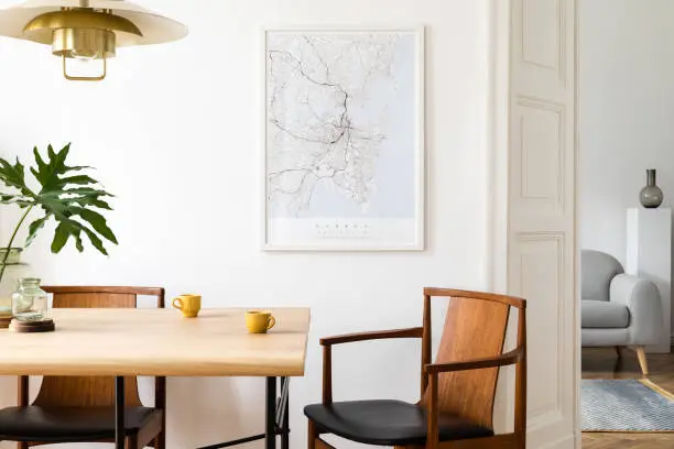 Stylish and modern dining room interior with mock up poster. Eclectic decor.