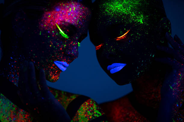 istock Two young women painted with fluorescent colors 1138360451