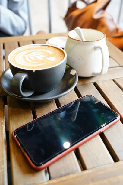 istock Mobile phone with coffee on a wooden table 1138360991