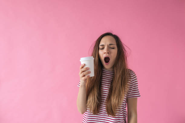 la ragazza con il caffè sbadiglia. - yawning women drink coffee cup foto e immagini stock