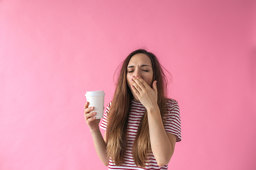 Una chica con café está bostezando. photo