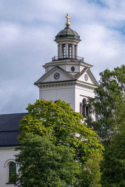 istock White church tower with lush green trees in sunlight 1138361511