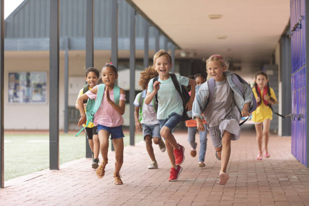 istock Happy school kids running in corridor 1138362412