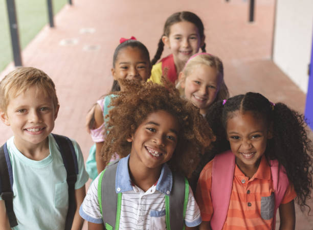 istock Happy school kids standing in corridor 1138362446