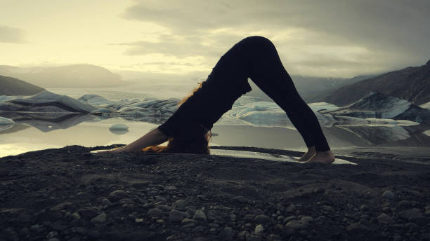 istock Downward facing dog pose. Woman doing yoga on glacier 1138364090