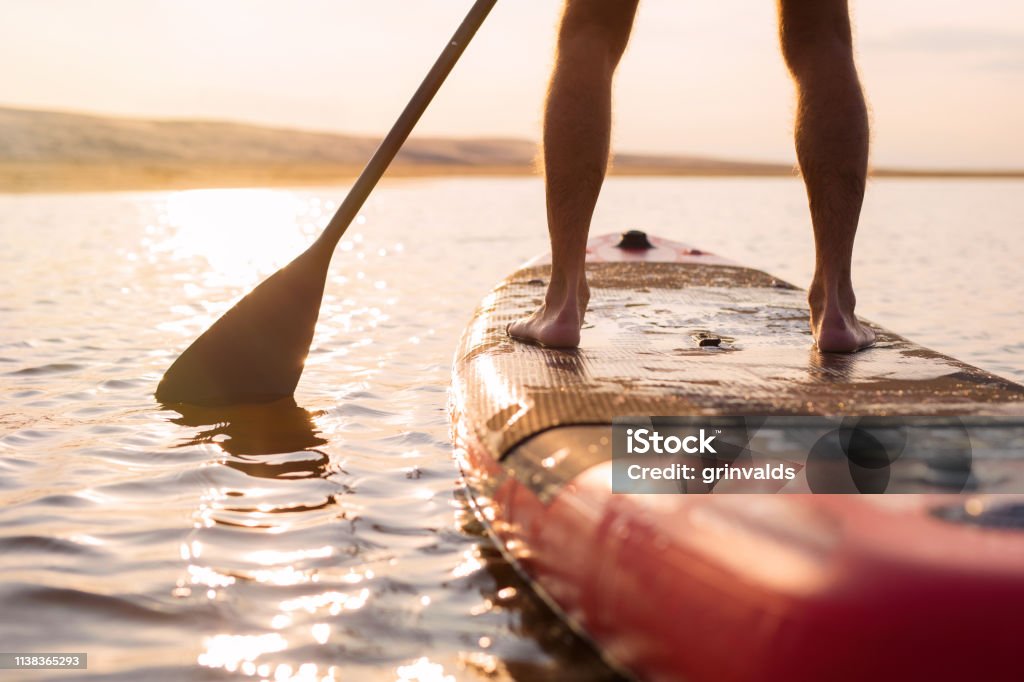Persoană pe bord cu zbaturi la apusul soarelui - Fotografie de stoc Paddleboard fără redevențe