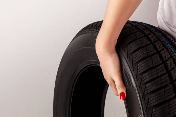 istock Woman hand holding car tire. 1138365331