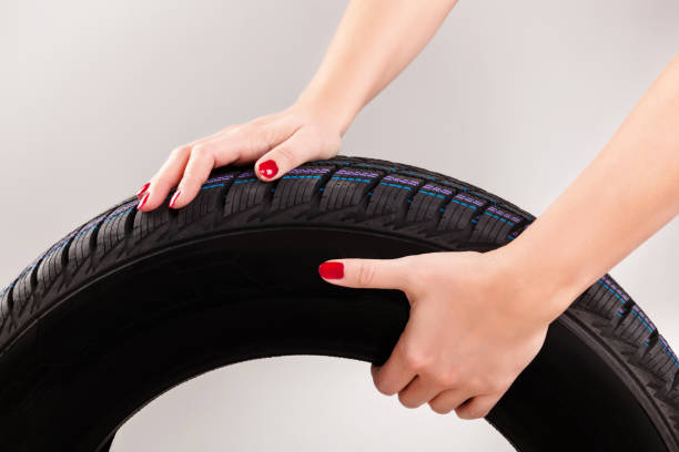 istock Woman hand holding car tire. 1138365336