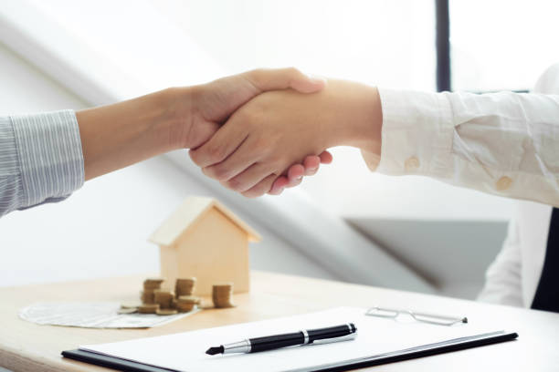 istock real estate agent shaking hands with client about property contract. 1138365434