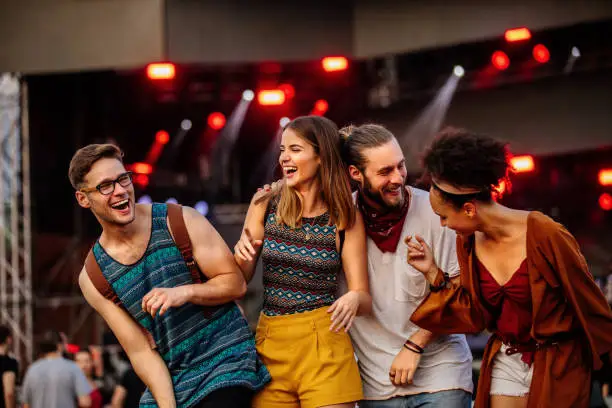Cropped shot of four friends having fun at a music festival