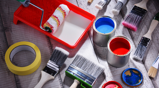 Paint can and paintbrushes of different size  for home decorating purposes.