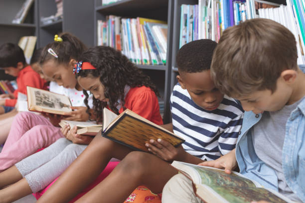 istock School kids sitting on cushions and studying over books in a library 1138365805