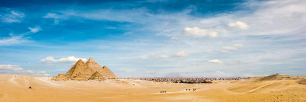Camel caravan in front of the Great pyramid of Giza complex - Cairo, Egypt