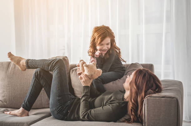 istock Mom and kid communicating on sofa with delight 1138370573