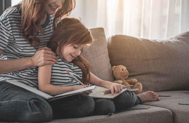 istock Happy child spending leisure drawing with her mom at home 1138370616