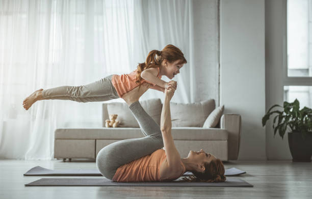 tochter genießt fitness mit mama zu hause - playful mother playing daughter stock-fotos und bilder