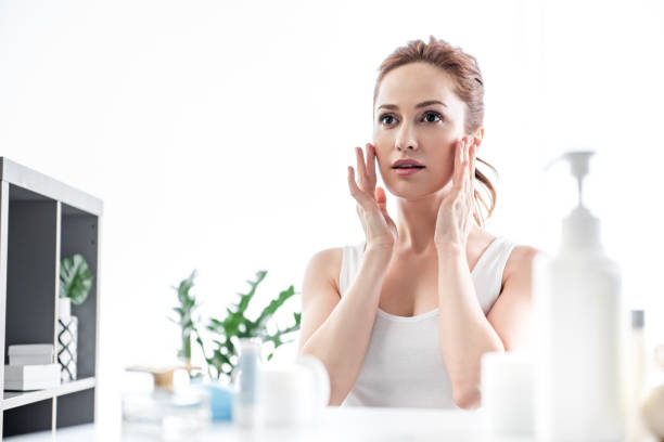 istock Attractive woman touching her face in bathroom 1138370647