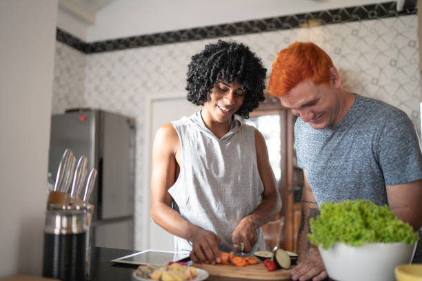 istock Young gay couple cooperating while cooking 1138371420