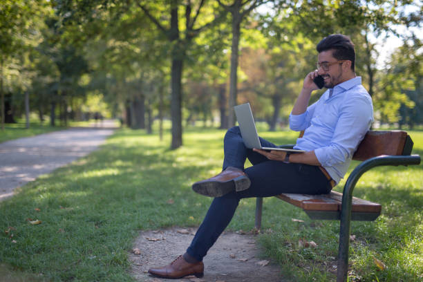 istock Handsome young businessman working on his laptop in the park 1138372013