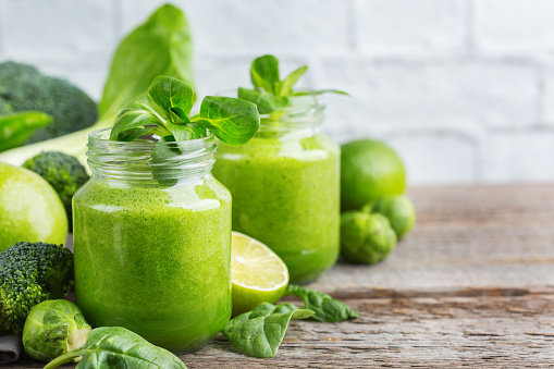 Food and drink, healthy dieting and nutrition, lifestyle, vegan, alkaline, vegetarian concept. Green smoothie with organic ingredients, vegetables on a modern kitchen table. Copy space background