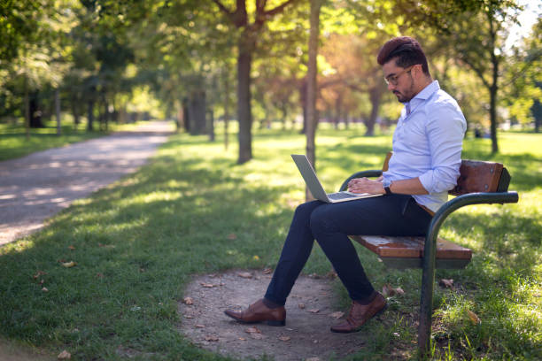 istock Handsome young businessman working on his laptop in the park 1138373211