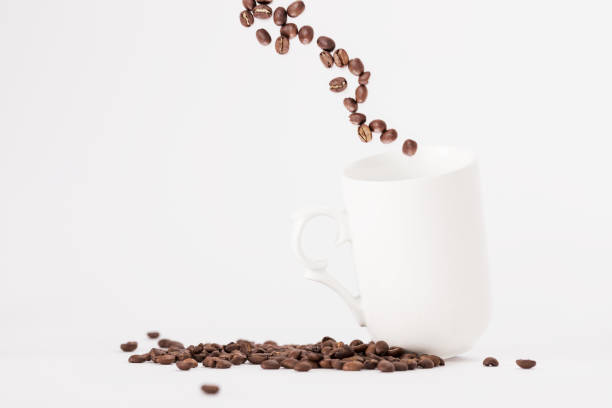 istock White Coffee Cup With Fresh Coffee Beans Fly Out of a Cup 1138373286