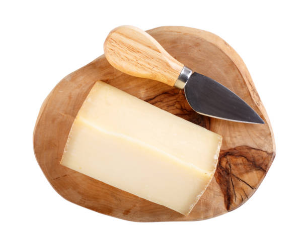 istock Pressed, uncooked French cheese comte on wooden board isolated on white.  Top view. 1138373592