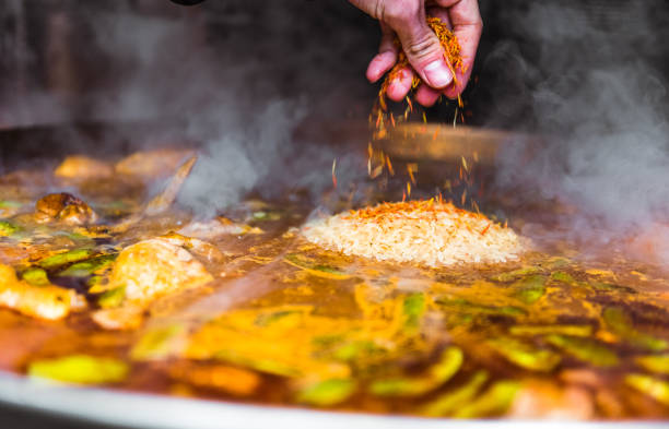 istock Cooking and making a traditional Spanish Paella over open fire. 1138374020