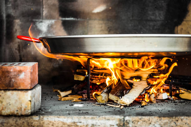 istock Cooking and making a traditional Spanish Paella over open fire. 1138374642