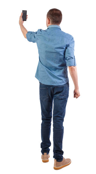 istock Back view of man who makes selfie with a smartphone. 1138374952